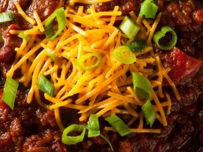 Chili covered in cheese and scallions